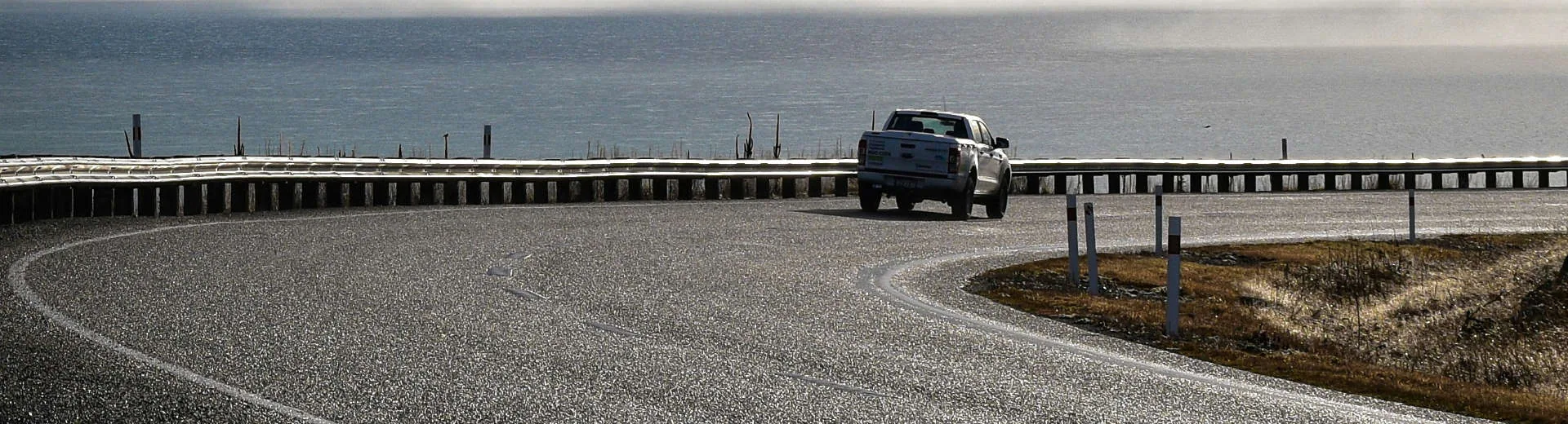 Silver ute on a scenic New Zealand coastal road — car finance